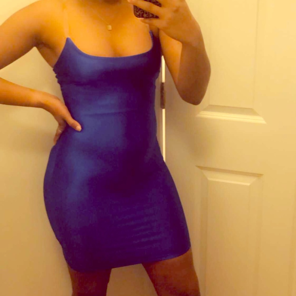 A blue body con dress with clear straps.